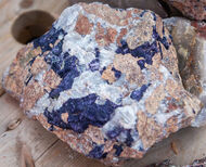 A fist-sized sample with large white and dark blue crystals.