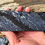 A section of drill core striped with zinc and silver-rich lead minerals.