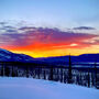 A bright orange sunset over the mountains in Yukon, Canada.