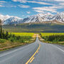 The Alaska Highway with beautiful northern mountains in the distance.