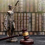 An adobe stock image of a statuette of Lady Justice beside a gavel.