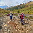 Geologists on an orange-stained mineralized outcrop in Northwest Alaska.