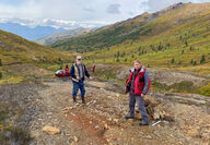 Curt Freeman, Rick Van Nieuwenhuyse at a mineralized outcrop at Sun in Alaska.