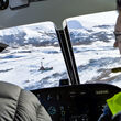Pilots flying over a drill rig on a snowy field in Southwest Alaska.