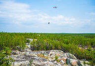 Helicopter flying supplies to remote drill rig near Fi pegmatite.