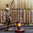 A figurine of Lady Justice holding scales next to a gavel.
