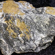 A large rock sample with large veins of high-grade gold visible on the surface.