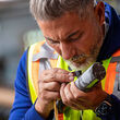 Nighthawk Gold CEO using a geologist loupe to take a closer look at drill core.