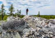 Li-FT geologist standing atop pegmatite outcrop at Yellowknife Lithium project.