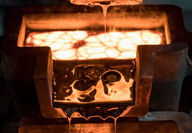 Molten gold being poured into molds to form solid ingots.
