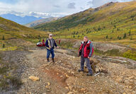 Geologists on an orange-stained mineralized outcrop in Northwest Alaska.