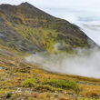 Drill on mountain ridge above clouds tests the Arctic Mine deposit in Alaska.