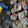 Rock hammer provides context for copper enriched rock samples.