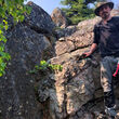 North Arrow geologist stands next to spodumene outcrop.