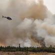 Crews in helicopters battle a forest fire near Yellowknife, NWT.