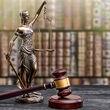 A statuette of Lady Justice holding scales next to a gavel.