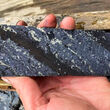 A section of drill core striped with zinc and silver-rich lead minerals.
