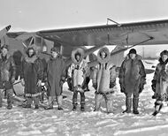 Star Air Services airmen posing in front of an airplane wearing warm clothes.