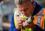 Nighthawk Gold CEO using a geologist loupe to take a closer look at drill core.