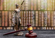 A figurine of Lady Justice holding scales next to a gavel.