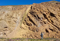 A geologist inspects a large rock face at the AGB gold-silver deposit in BC.