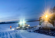 Two snowcats plow snow for winter road to gold project in Alaska.