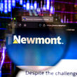 A smartphone displays a Newmont webpage before an up-trending stock chart.