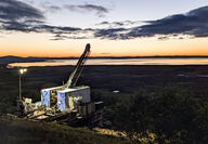 A colorful dusk horizon backdrops a drill testing the Graphite Creek deposit.