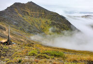 Drill on mountain ridge above clouds tests the Arctic Mine deposit in Alaska.