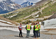 Fireweed Metals crew holding a briefing on a slope at Macmillan Pass, Yukon.