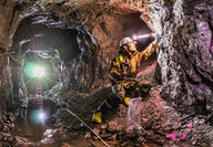 A geologist grabs samples from the walls of a historic underground silver mine.