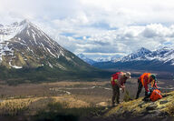 Geologists inspect a hill in the foreground of the beautiful Yukon wilderness.