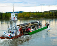 Barge carries truck loaded with copper concentrate across Yukon River.