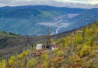 The Pogo Mine can be seen behind a drill testing for gold on a fall Alaska day.