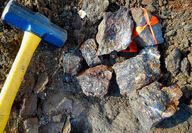 A sledgehammer alongside highly mineralized broken rock at Silver Lime.