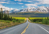 The Alaska Highway with beautiful northern mountains in the distance.
