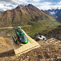A helicopter sits on a drill pad on a highly mineralized mountain in the Yukon.