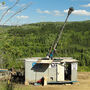 A drill rig tests for gold at Golden Summit on a warm summer day in Alaska.