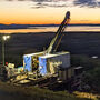A western Alaska sunset colors the horizon behind a drill at Graphite Creek.