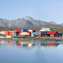 The iconic red and blue buildings at Red Dog reflect off pond at the zinc mine.