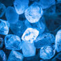 A closeup of rough diamonds lit with a soft blue light.