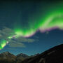 The northern lights shine brilliantly over the Mackenzie Mountains.