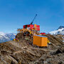 A drill tests for gold from atop a mountain ridge in Northern British Columbia.