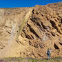 A geologist inspects a large rock face at the AGB gold-silver deposit in BC.