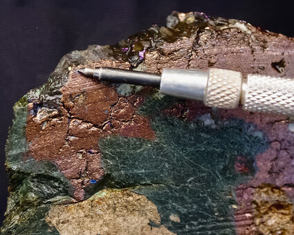 Closeup of rock sample with massive native copper and visible gold.