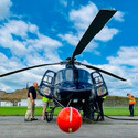 A boom with orange ball-shaped instrument on the front of a helicopter.