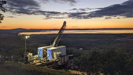 A colorful sunset paints the horizon orange at the Graphite Creek project in AK.