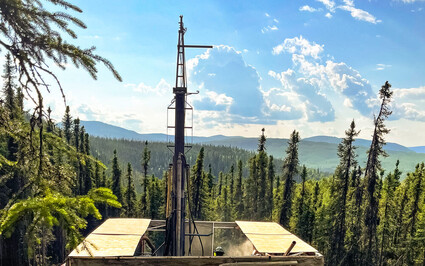 Looking over the top of a drill testing for gold on a warm summer day in Alaska.