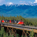 CN Rail train crossing a bridge in the wilderness of Canada.