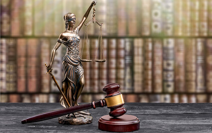 A statuette of Lady Justice holding scales next to a gavel.